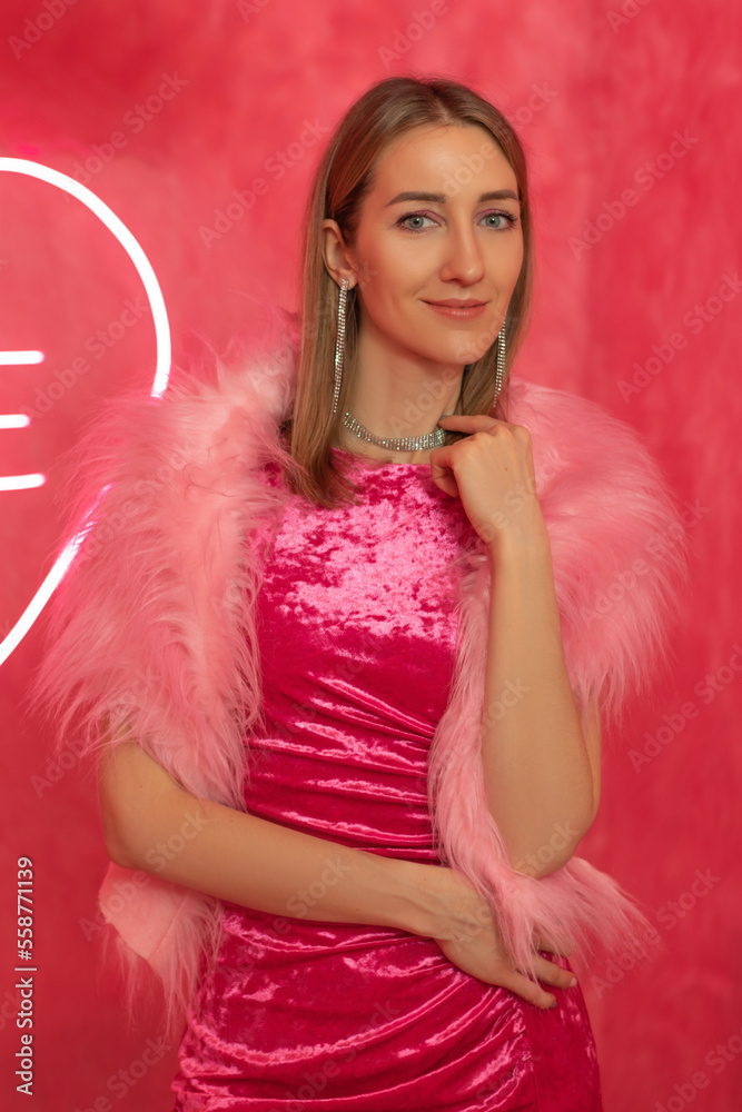 Young pretty woman in pink dress closeup on the pink fur backgroud Young pretty woman in pink dress closeup on the pink fur backgroud