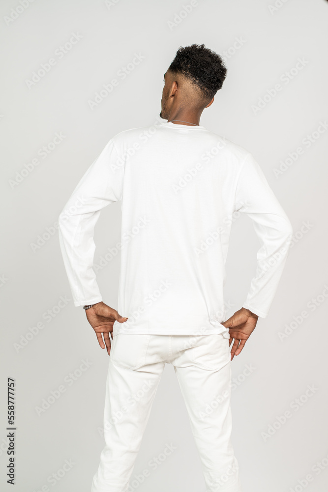 Back side image of an african man wearing white blank long sleeve shirt, doing a pose with both of his hand on his waist Back side image of an african man wearing white blank long sleeve shirt, doing a pose with both of his hand on his waist