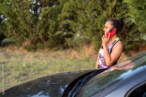 talking on a cell phone leaning against a car in the open air © Lautaro