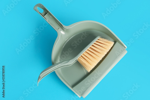 Cleaning brush and dustpan on color background