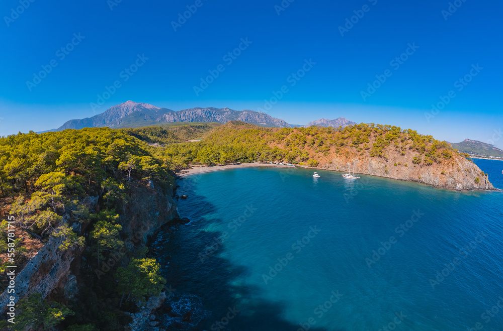Aerial view Quiet blue lagoon with clear turquoise water and white yacht against backdrop mountains of Turkey