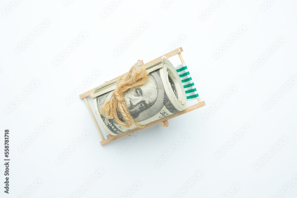 Fototapeta premium A flatlay picture of fake cash at the folding beach chair. Retirement and vacation concept.