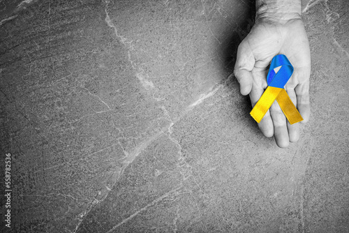 blue yellow ribbon lies on the male palm