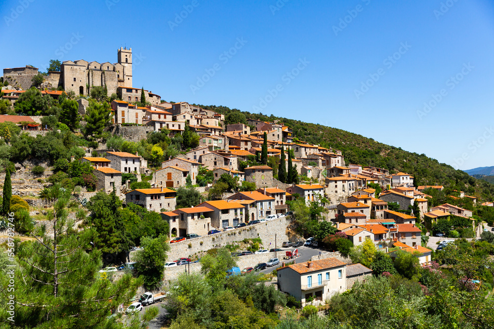 Sunny summer landscape of old stone village Eus, France