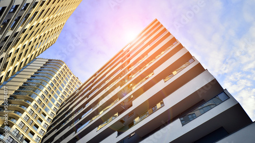 The narrow passage between modern residential buildings. Walls of high-rise apartment buildings and a narrow strip of sky between them. Modern urban living districts. Bottom view.
