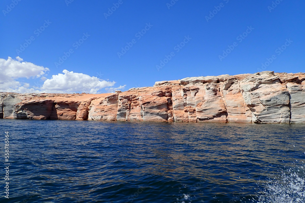 Water splashing from a watercraft and Colorful sandstone rock formations along the Colorado River at Glen Canyon National Recreation Area
