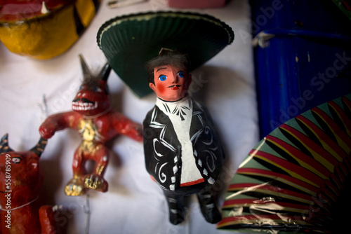A mariachi paper mache doll and a red devil are displayed in a Mexican folk-art workshop. photo