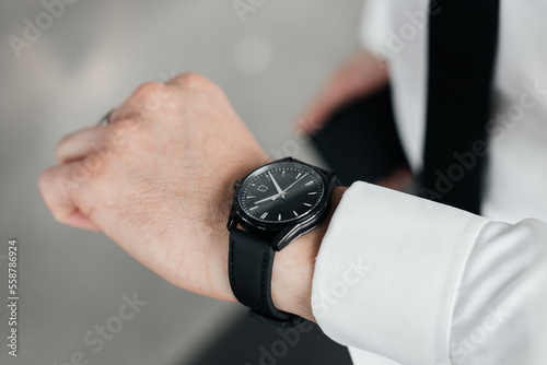 man's hand in a white shirt and a mechanical watch on his wrist