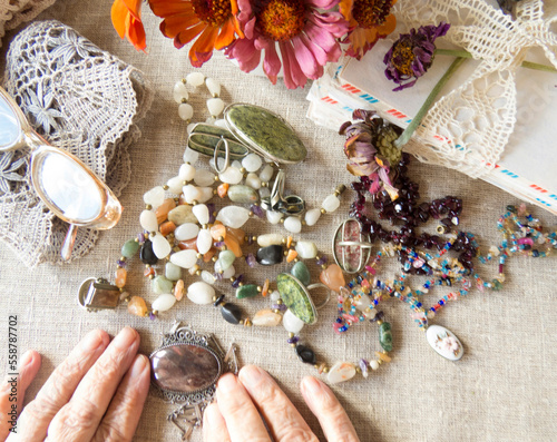 Beautiful  image of an older lady's hands   with    jewellery, bijouterie, flowers.   Memoirs, solitariness, melancholia   Selective focus photo