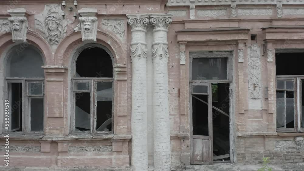 Abandoned old manor (mansion) house in the neoclassical style with an abundance of decor and broken windows. Deserted building of the 19th century. Shot in log profile. Aerial side view