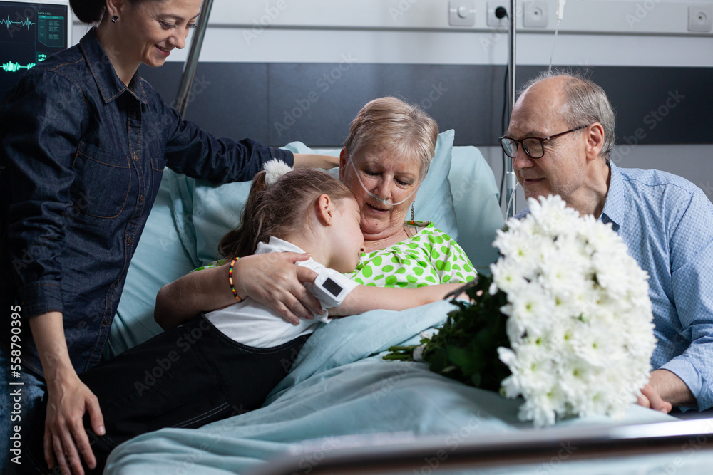 Fotka „Little granddaughter giving flowers bouquet to sick grandmother