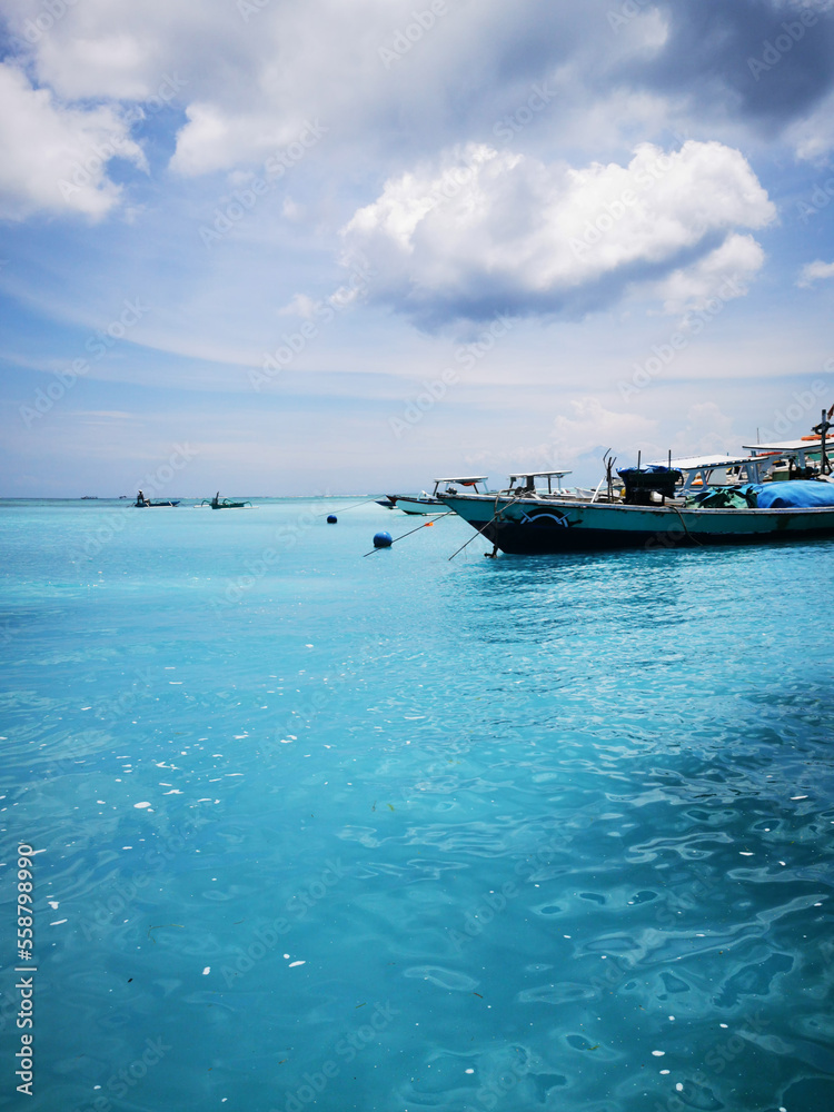 Boote im strahlend blauen und klaren Meer vor den Gili Inseln, Gili Trawangan, Indonesien