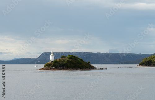 Yacht approaching the lighthouse in Macquarie Harbour, Tasmania. Landscape view from the Gordon river cruise. photo