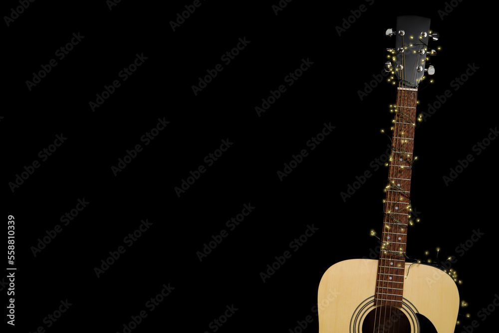 Guitar with fairy lights on black background, space for text