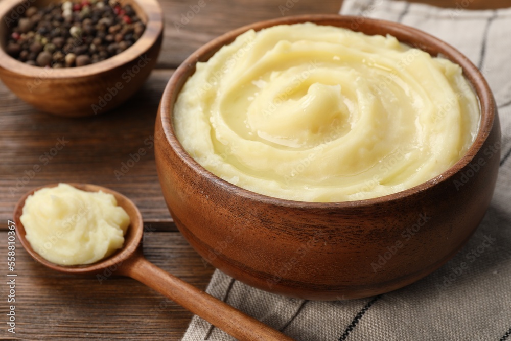 Bowl of tasty mashed potato and pepper on wooden table, closeup Bowl of tasty mashed potato and pepper on wooden table, closeup