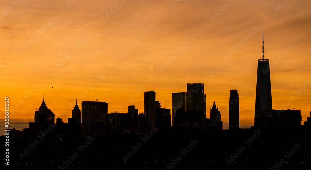 Manhattan skyline with golden orange sky at sunset. silhouette photo, New York City.