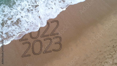 New year 2023 handwritten in the sand surface
