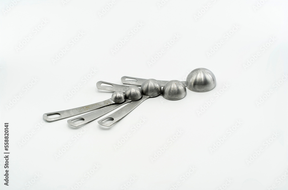 Empty measuring spoons upside-down on white surface Empty measuring spoons upside-down on white surface