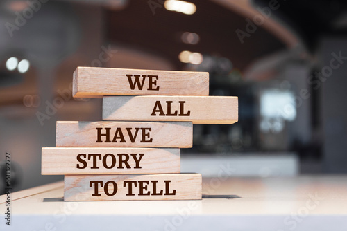 Wooden blocks with words 'We All Have Story To Tell'.