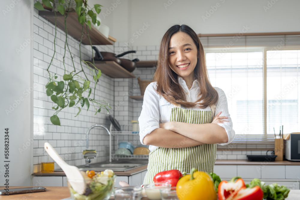 Portrait of attractive asian japanese woman in kitchen at home, young girl browsing website on tutor cooking class and doing for kitchen, cutting vegetables, cooking, cooking concept. Portrait of attractive asian japanese woman in kitchen at home, young girl browsing website on tutor cooking class and doing for kitchen, cutting vegetables, cooking, cooking concept.