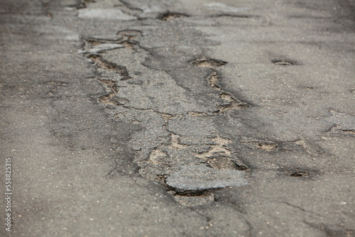  asphalt road broken with holes and cracks