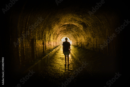 Silhouette of a man standing in a tunnel