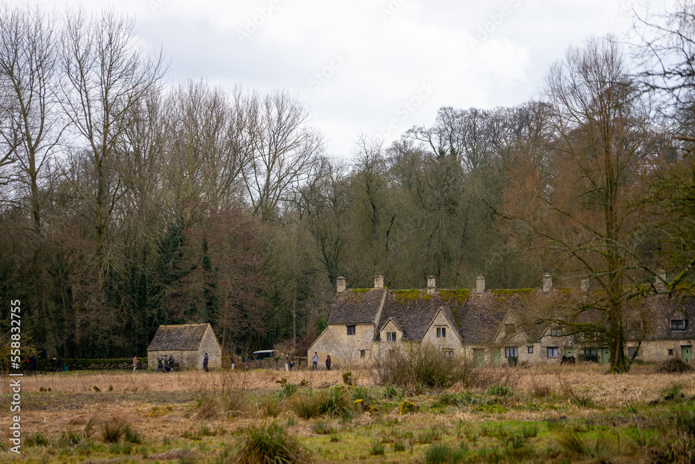 Fototapeta premium Arlington Row in Bibury , classic villages in Cotwolds wonderful stone buildings and river coln during winter cloudy day at Gloucestershire , United Kingdom : 6 March 2018