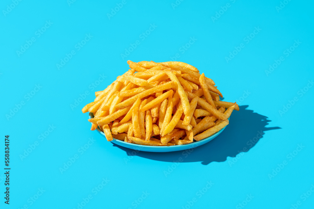 French fries plate minimalist on a blue background. French fries plate minimalist on a blue background.