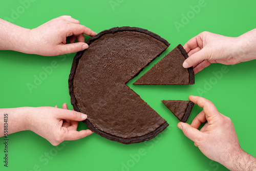 Pie chart concept, people sharing chocolate cake, above view on a green background.