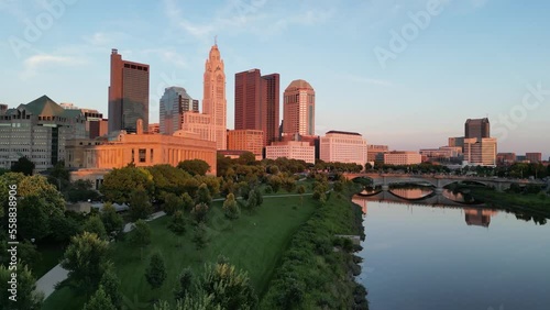 Aerial golden hour ascent to city skyline from trees - Columbus, Ohio photo