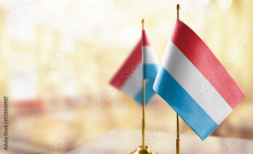 Small flags of the Luxembourg on an abstract blurry background