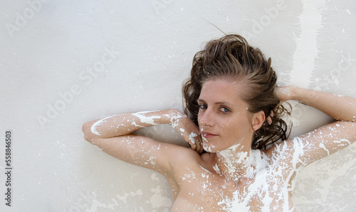 Schilderij op canvas portrait of a sexy young brunette lying woman with dots of white color paint