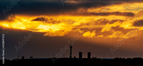 Sonnenstrahlen brechen über dem Olympiastation und dem Messeturm in Berlin durch die Wolken.