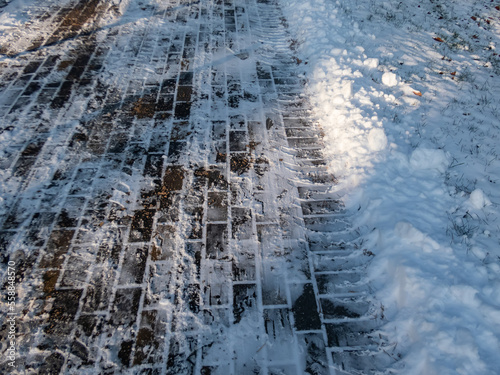 Salt and sand on icy and snowy sidewalk in the winter. Applying salt and sand to surface to keep roads clear and people safe in winter