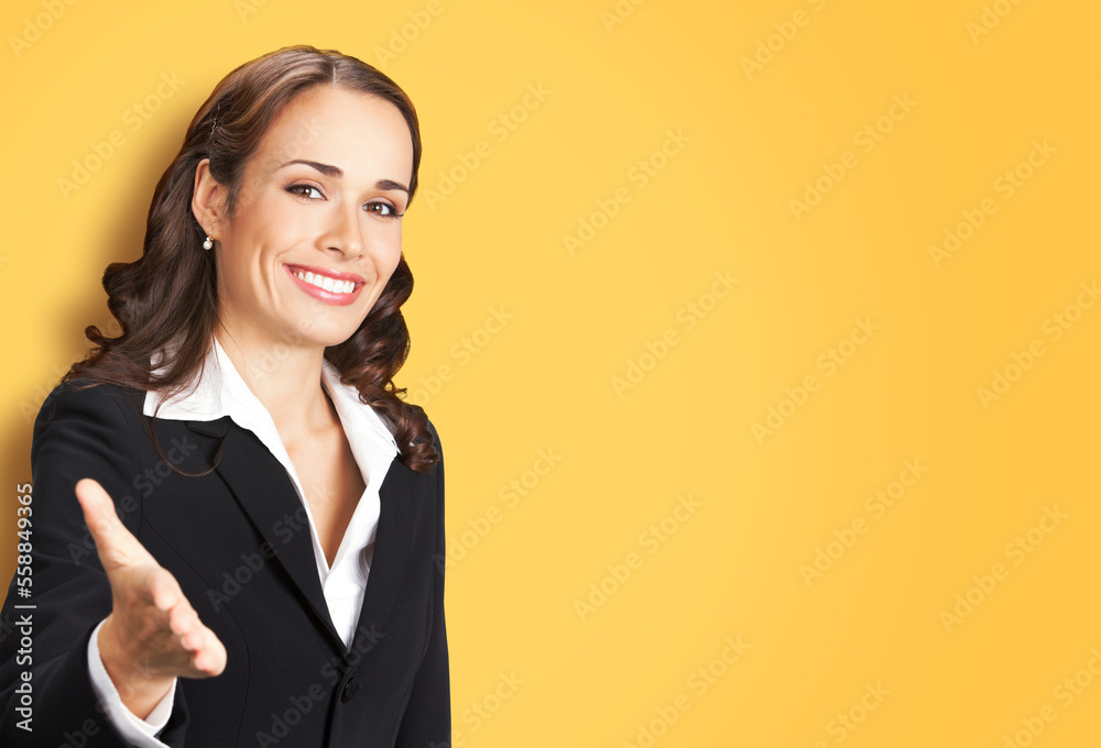 Portrait image of happy smiling business woman in black confident suit giving hand for handshake, isolated on yellow background. Female executive office worker, teacher or real estate agent. Portrait image of happy smiling business woman in black confident suit giving hand for handshake, isolated on yellow background. Female executive office worker, teacher or real estate agent.