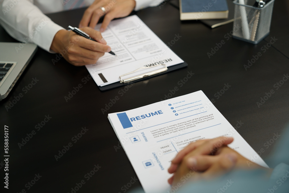 Examiner reading a resume during job interview at office Business and human resources concept. Examiner reading a resume during job interview at office Business and human resources concept.