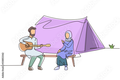 Single continuous line drawing Arabian couple tourist camping. Camper sitting by campfire next to camp tent, guy playing music guitar, people enjoy nature picnic. Outdoor summer tourism. One line draw