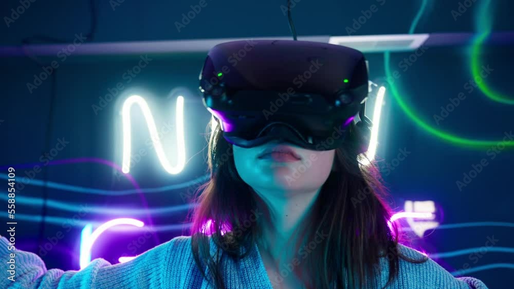 Cyber gamer in VR glasses plays virtual reality game in neon futuristic ...