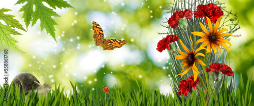A bouquet of beautiful flowers on a blurred green background. Butterfly flies next to thel bouquet
