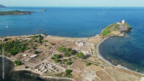 Nora Peninsula and Archeological site with ancient Roman ruins in Sardinia, Italy - Aerial backwards photo