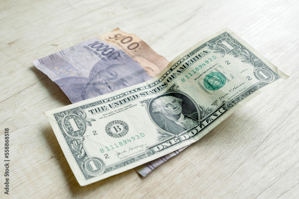 One dollar bills and 15,000 rupiah banknotes. Currency exchange concept One dollar bills and 15,000 rupiah banknotes. Currency exchange concept