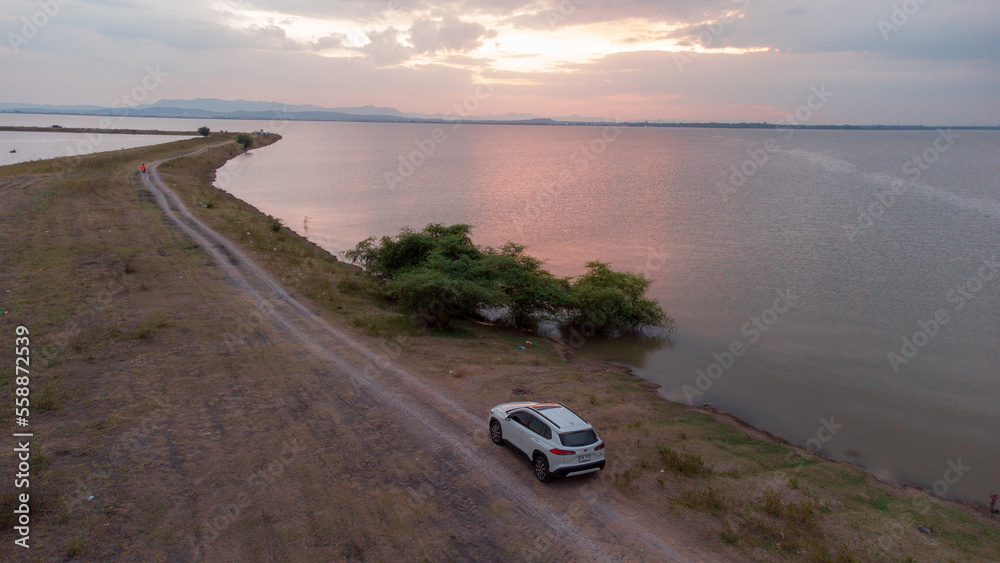 Fototapeta premium White car over the dam and large river in Pasak dam in Thailand during the rainy season with a flood pandemic.