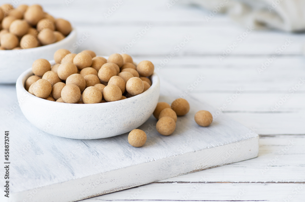 Brown Soy-covered Chickpeas with sauce in wooden bowl, traditional turkish coated nut Brown Soy-covered Chickpeas with sauce in wooden bowl, traditional turkish coated nut