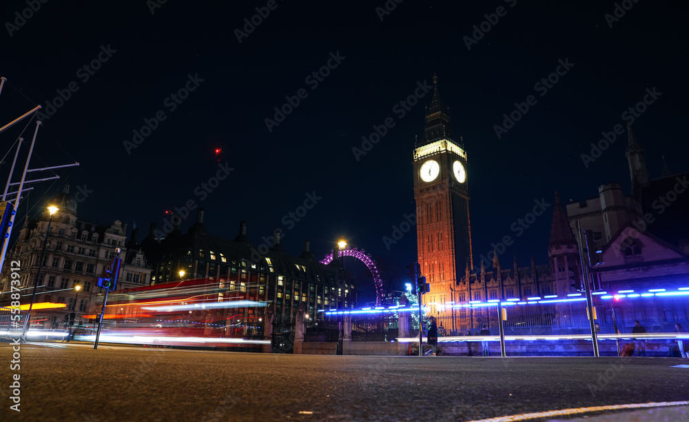 Travel to London. Big Ben Clock Tower photographed during the night with long exposure, traffic lights in front of it.