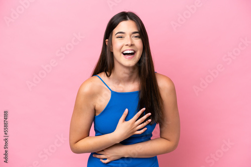 Young Brazilian woman isolated on pink background smiling a lot