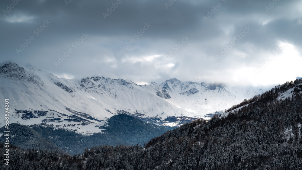 Mountain landscape. Cold mountain. Alps at sunset. Towering blue cloud.Glacier in the mountains.Panorama on top of a snowy mountain near Saint Jean de Maurienne. Saint Jean de Maurienne in the French 