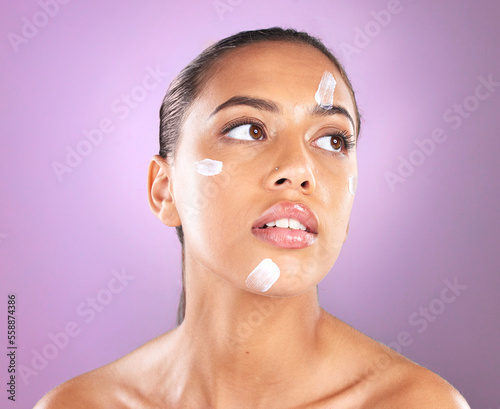Woman face, skincare and beauty cream or lotion for dermatology, health and wellness of natural glow skin on purple background. Headshot of aesthetic cosmetics model in studio with sunscreen product