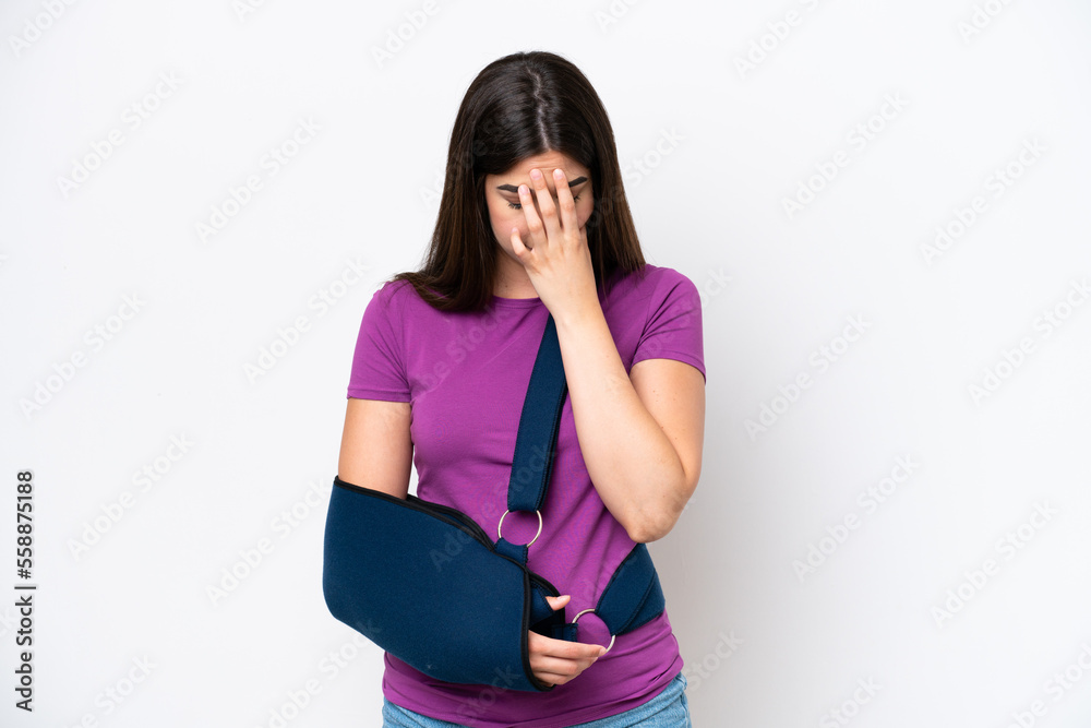 Young Brazilian woman with broken arm and wearing a sling isolated on white background with tired and sick expression Young Brazilian woman with broken arm and wearing a sling isolated on white background with tired and sick expression