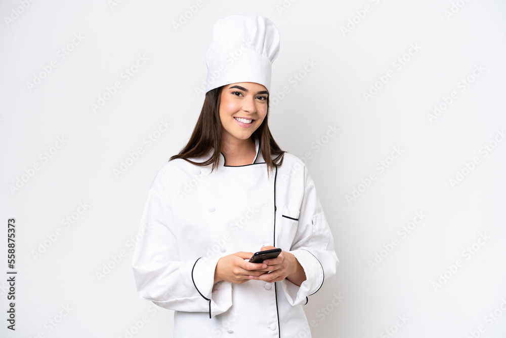 Young Brazilian chef woman isolated on white background sending a message with the mobile Young Brazilian chef woman isolated on white background sending a message with the mobile