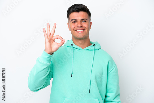 Young caucasian handsome man isolated on white background showing ok sign with fingers © luismolinero